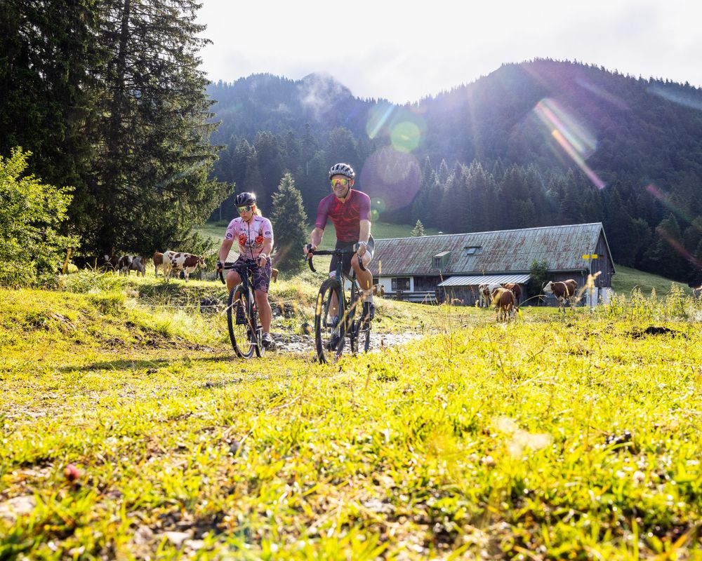 Radfahrer mit Alm im Hintergrund