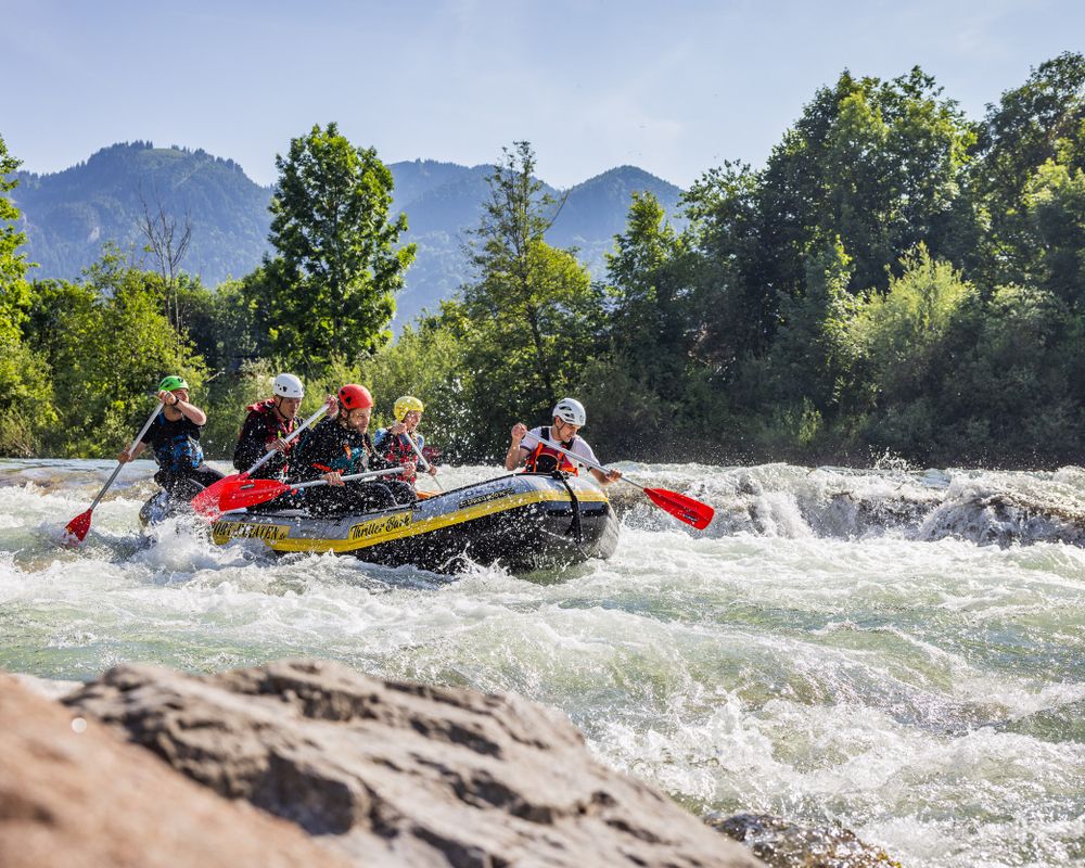 Rafting Boot mit sieben Personen auf der wilden Isar in Lenggries. 